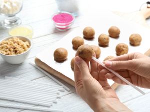 stick cake pops coat in chocolate and decorate