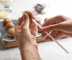 dip cake pop stick in melted chocolate and stick into cake pop