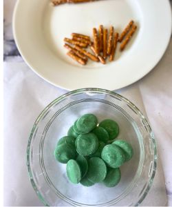 break pretzels and melt green chocolate for stems for easy pumpkin Oreo truffles