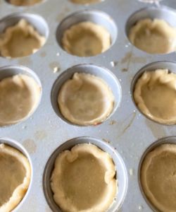 place pie dough into muffin tin