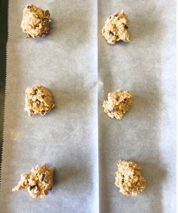 spoon oatmeal chocolate chip with toffee cookie dough onto baking sheet