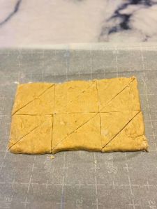 cut vegan maple scone dough into triangular wedges