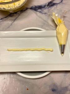 line of lemon buttercream on cake board