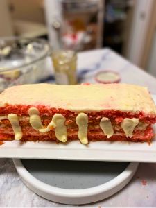 pipe frosting down the sides of strawberry lemon rectangular layer cake