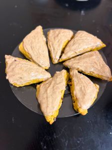 spread browned butter maple glaze on pumpkin chocolate chip scones