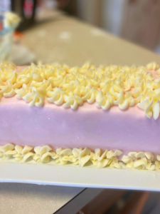 strawberry lemon rectangular layer cake decorated with fondant and buttercream flowers