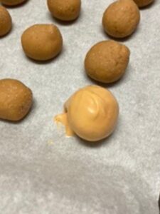 place salted caramel cookie butter truffle back on cookie sheet to set