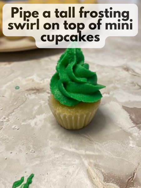 pipe frosting onto mini cupcake