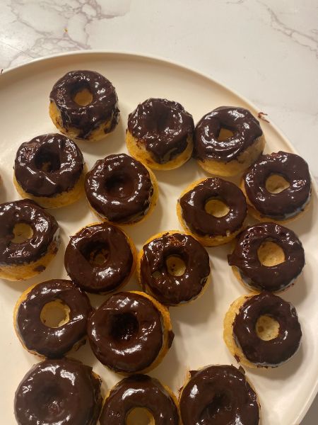 mini donuts with chocolate frosting sitting on a plate