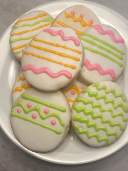 cookies cut in the shape of eggs and decorated like Easter eggs