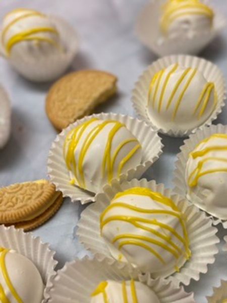 Lemon Oreo balls covered in white chocolate with a yellow chocolate drizzle