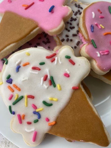 sugar cut-out cookies in the shape of and decorated like ice cream cones with sprinkles