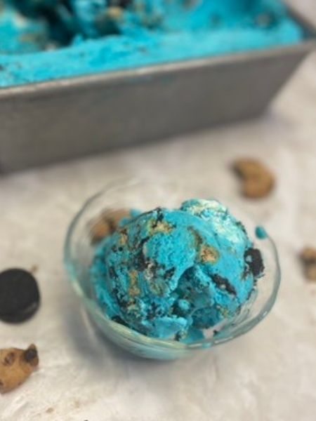 bright blue ice cream sprinkled with chunks of chocolate chip cookies and Oreos