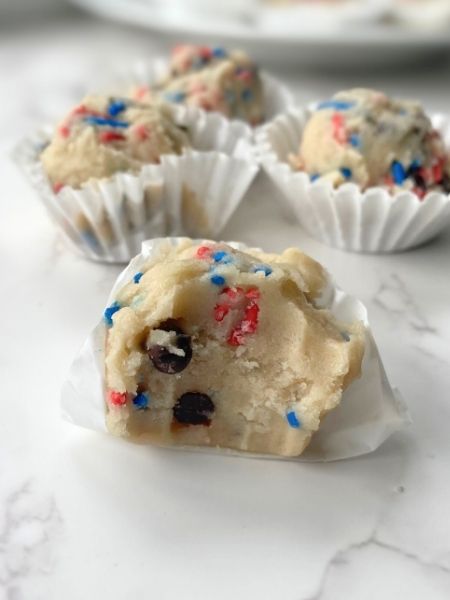 edible cookie dough balls with mini chocolate chips and red and blue sprinkles