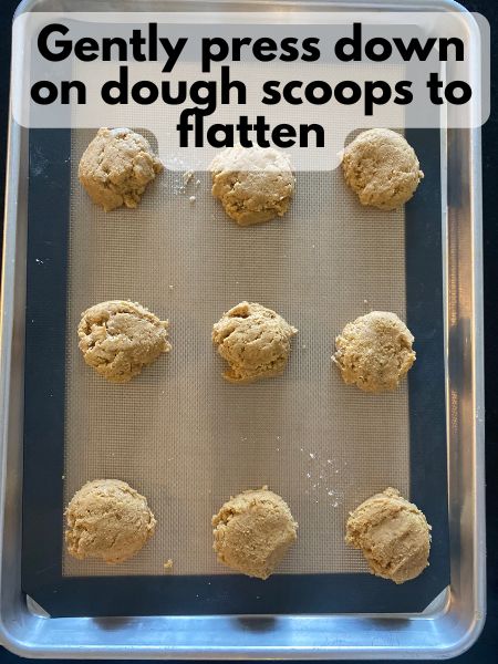 pumpkin sugar cookie dough flattened on a baking sheet