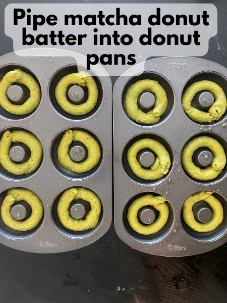 matcha donut batter piped into a donut pan