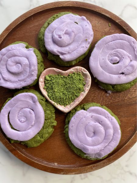 matcha lavender sugar cookies on a wooden cake stand with matcha powder