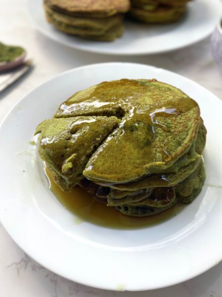 matcha pancakes with syrup on a plate