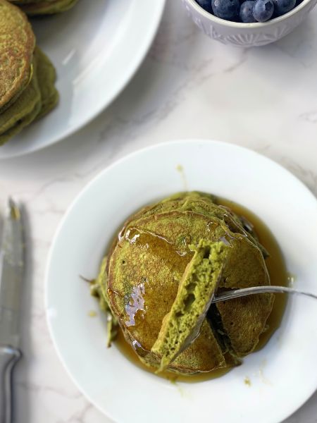 matcha pancakes with a bite of pancake on a fork