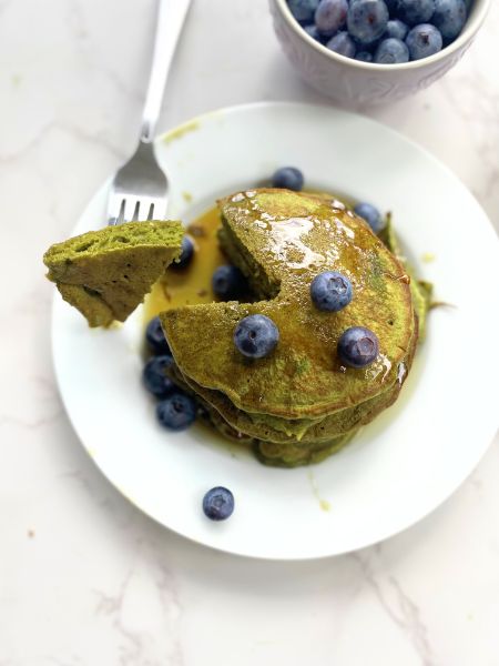 matcha pancakes topped with blueberries and syrup