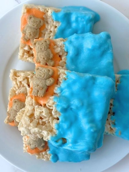 rice krispie treat decorated with blue chocolate for water and a teddy graham cracker on a chocolate towel