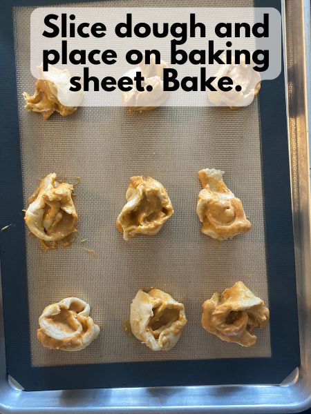 uncooked pumpkin cream cheese pinwheels on a baking sheet