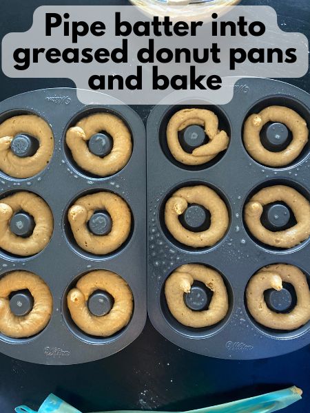 pumpkin donut batter piped into a donut pan