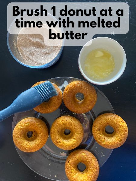 brushing butter on a pumpkin donut