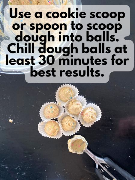 birthday cake cookie dough in a cookie scoop, some cookie dough balls are sitting in mini cupcake liners on a table