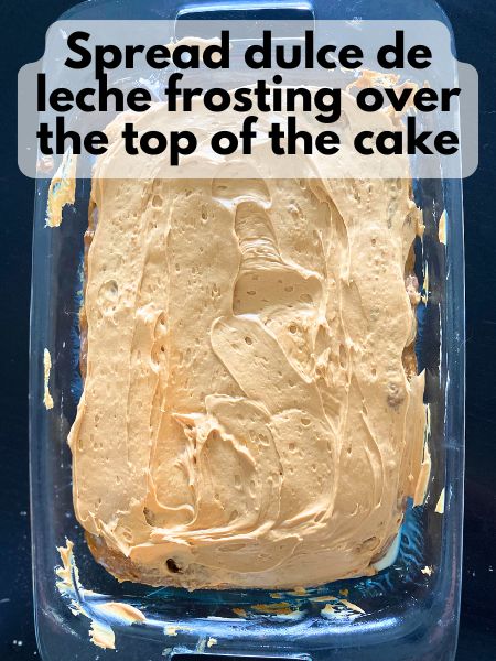 dulce de leche frosting spread over pumpkin poke cake