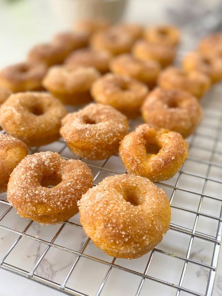mini pumpkin cinnamon sugar donuts on a cooling rack