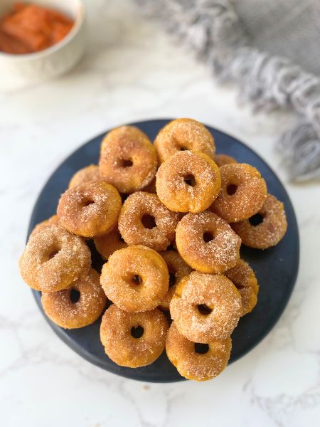 mini pumpkin cinnamon sugar donuts on a plate