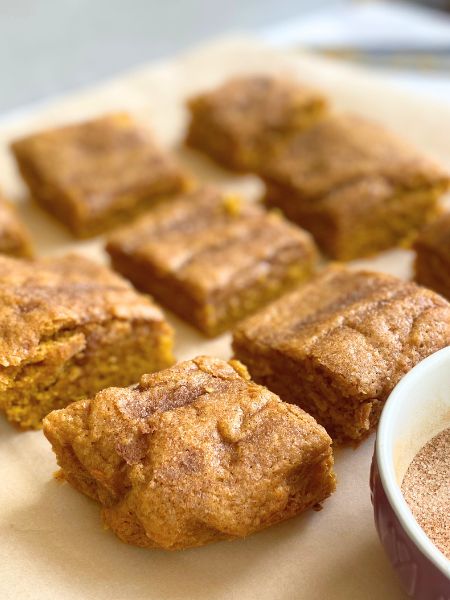 pumpkin snickerdoodle bars on parchment paper