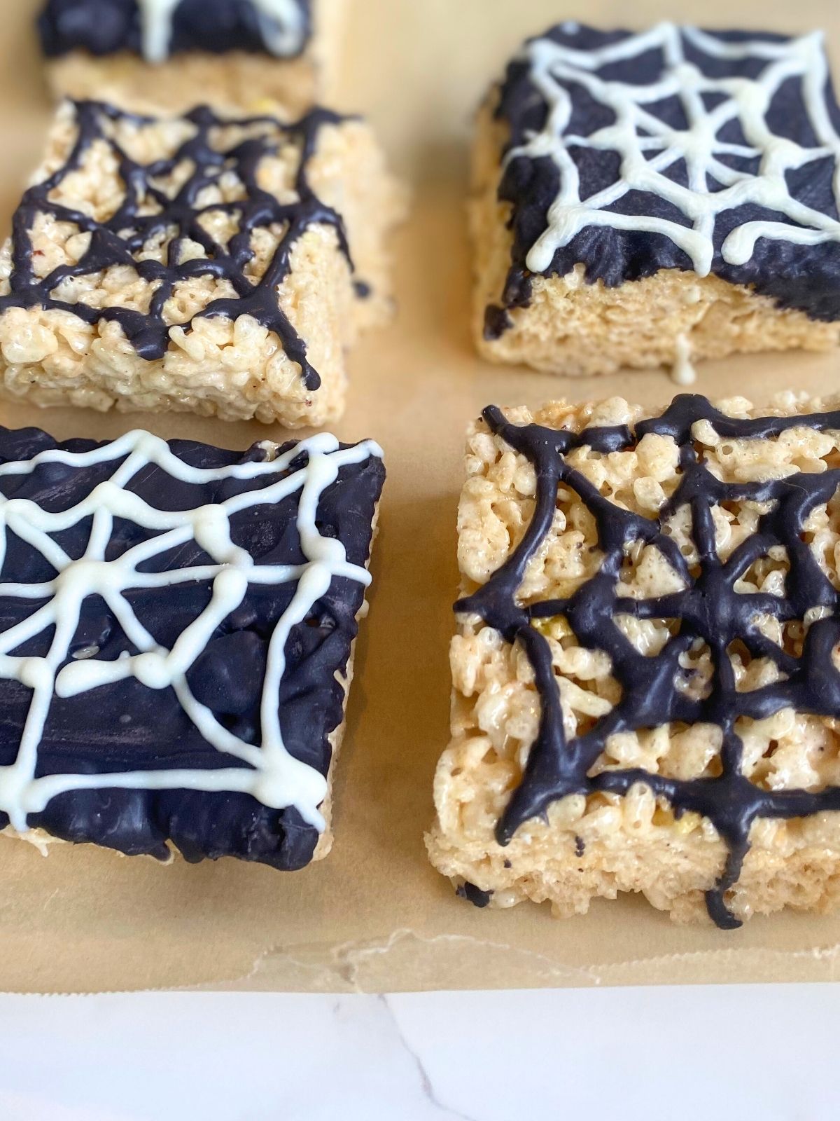 spider web rice krispie treats sitting on parchment paper