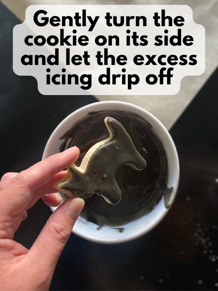 excess royal icing dripping off cat cookie