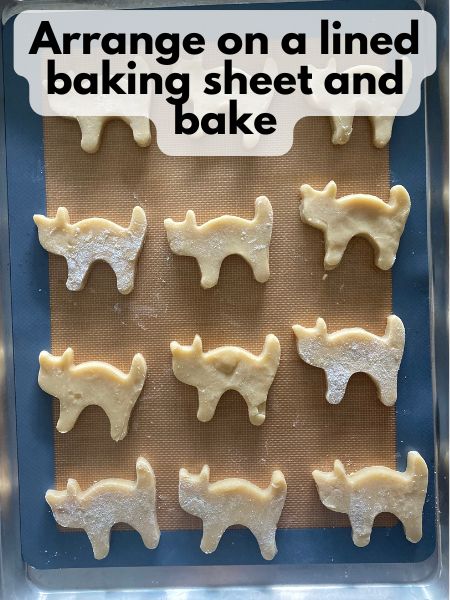 cat cutout cookies on lined baking sheet