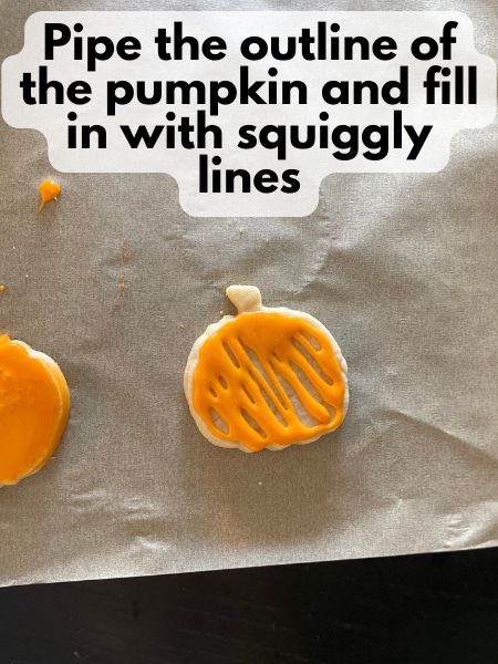 piped royal icing on pumpkin cookie