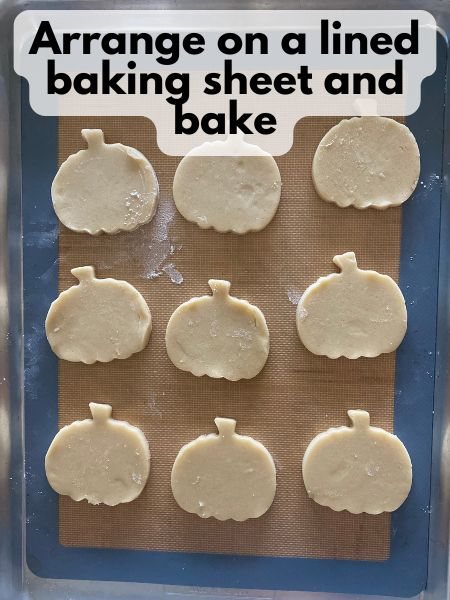 pumpkin sugar cookies arranged on baking sheet