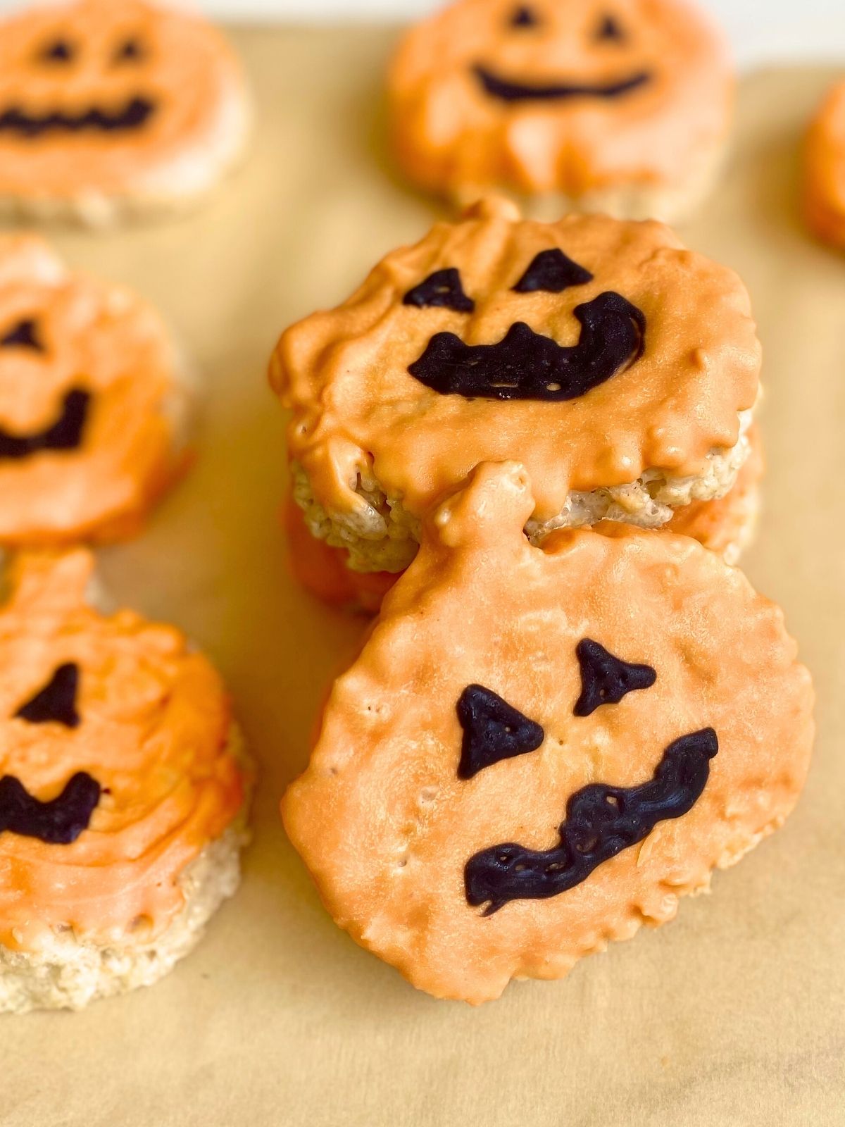 jack o lantern rice krispie treats sitting on parchment paper