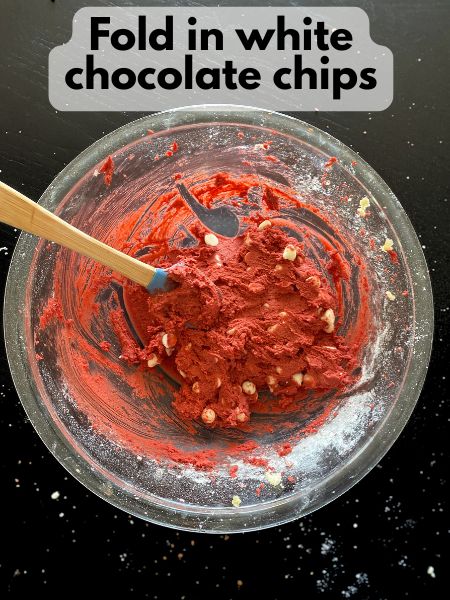 white chocolate chips folded into red velvet cookie dough