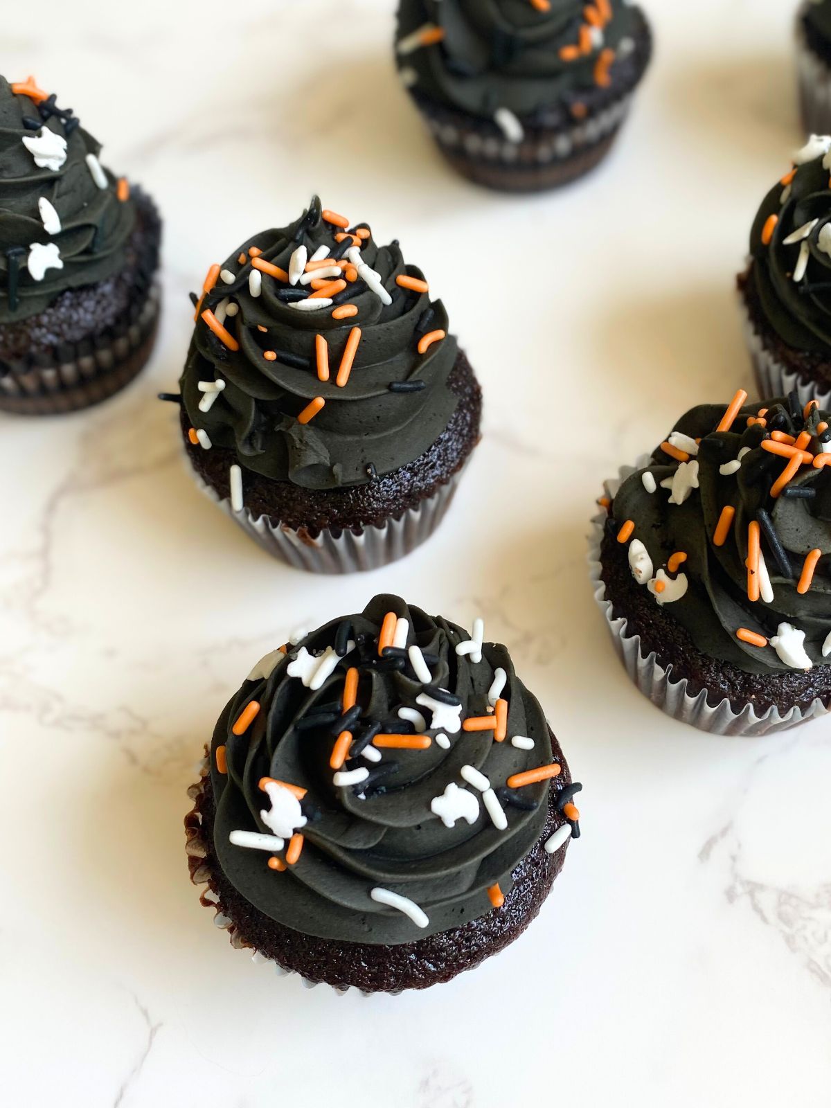 black frosted halloween cupcakes with frosting and sprinkles