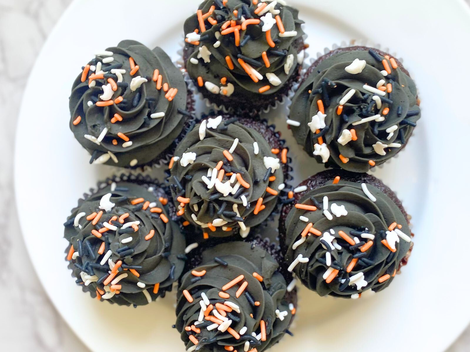 black frosted halloween cupcakes on a plate