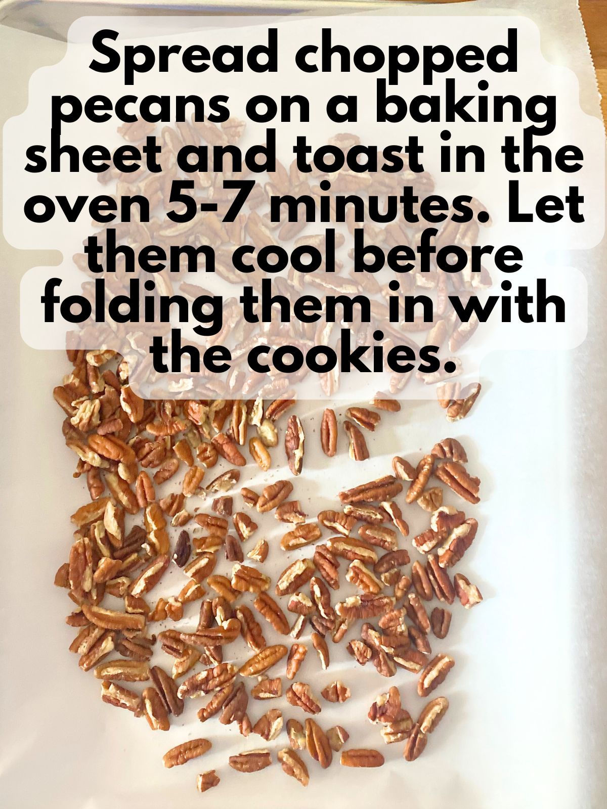 pecans spread on a baking sheet lined with parchment paper