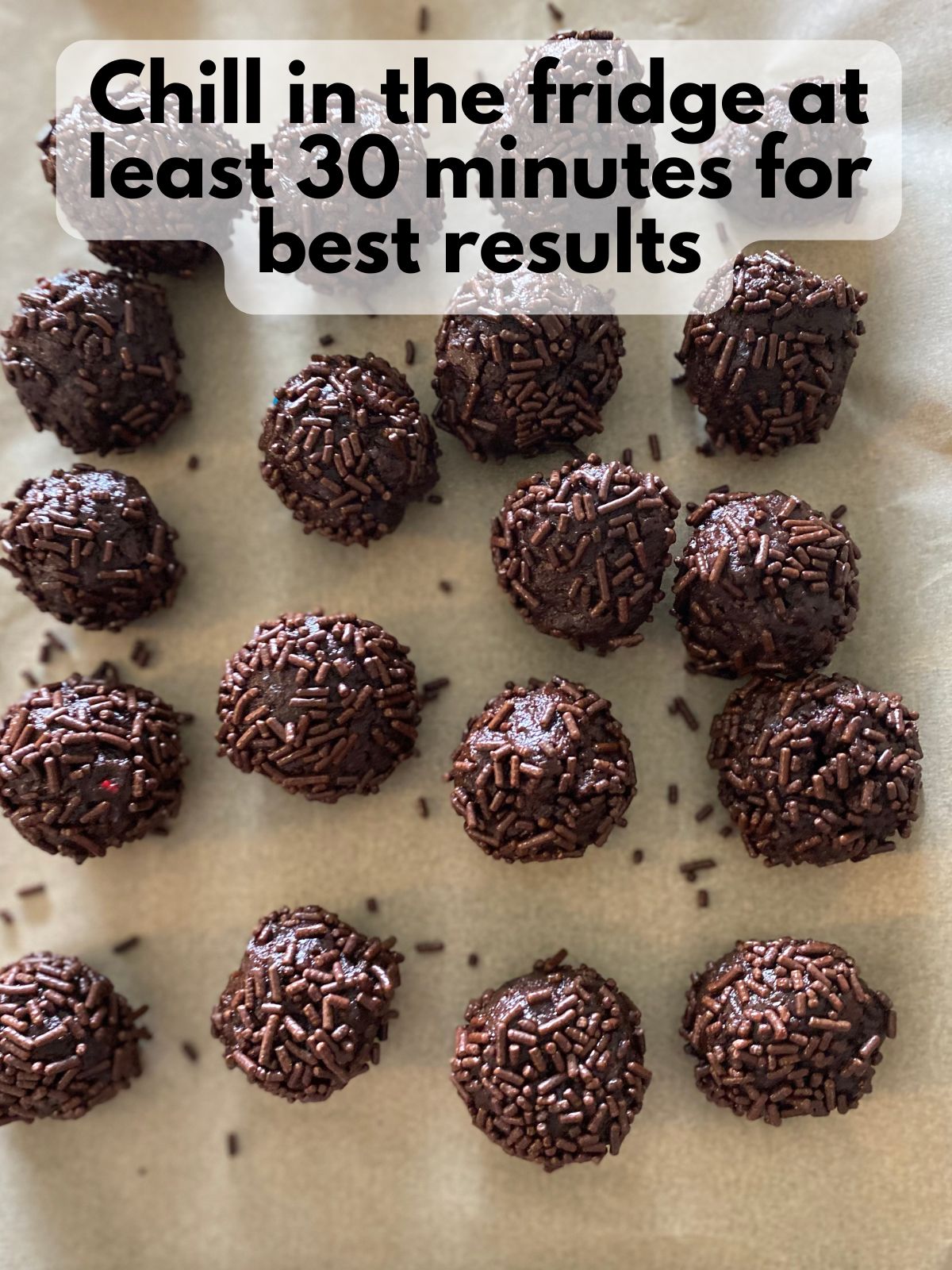brownie truffles coated in sprinkles on a baking sheet lined with parchment paper