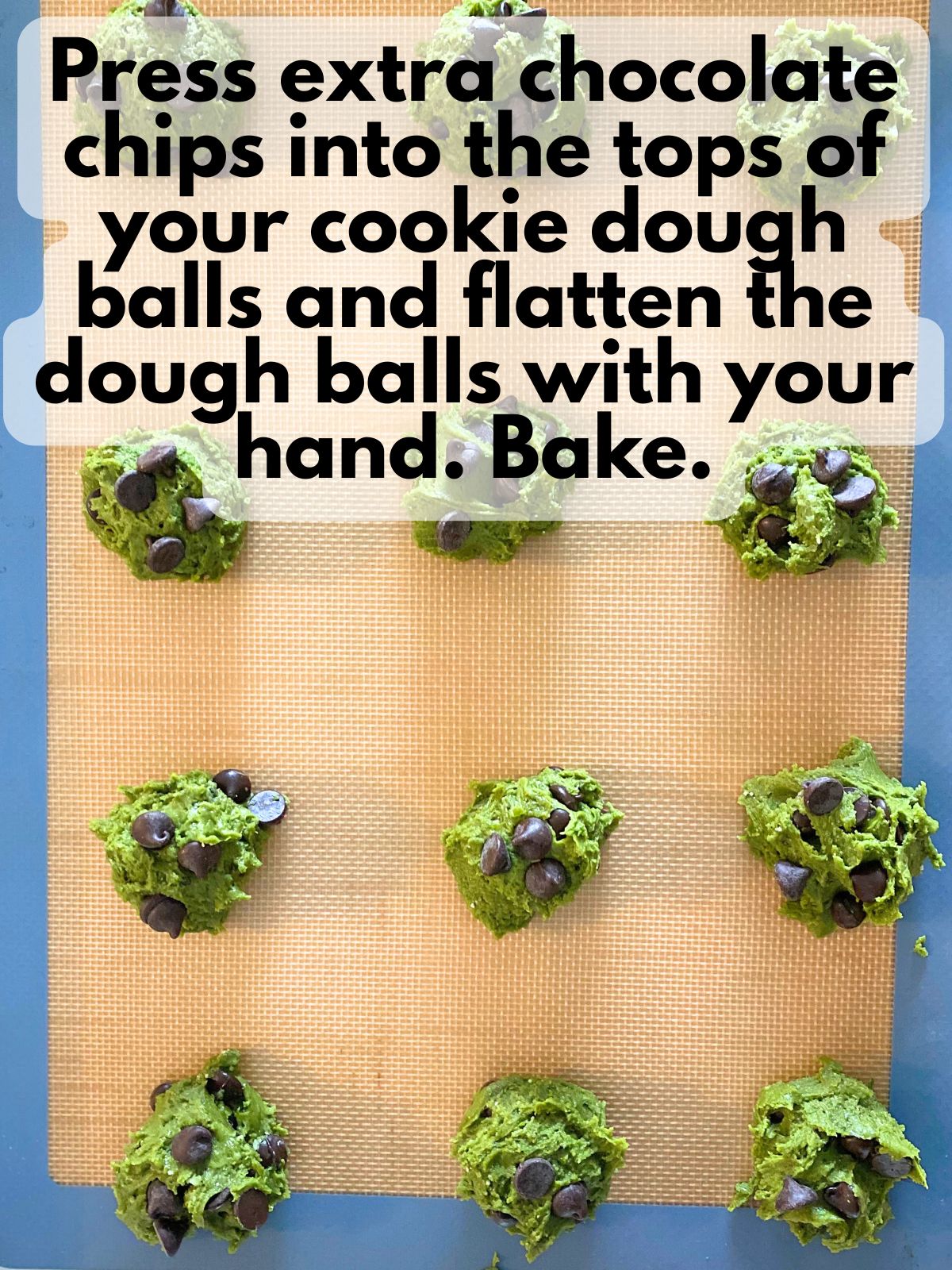 chocolate chips pressed into the tops of matcha cookie dough on a baking sheet