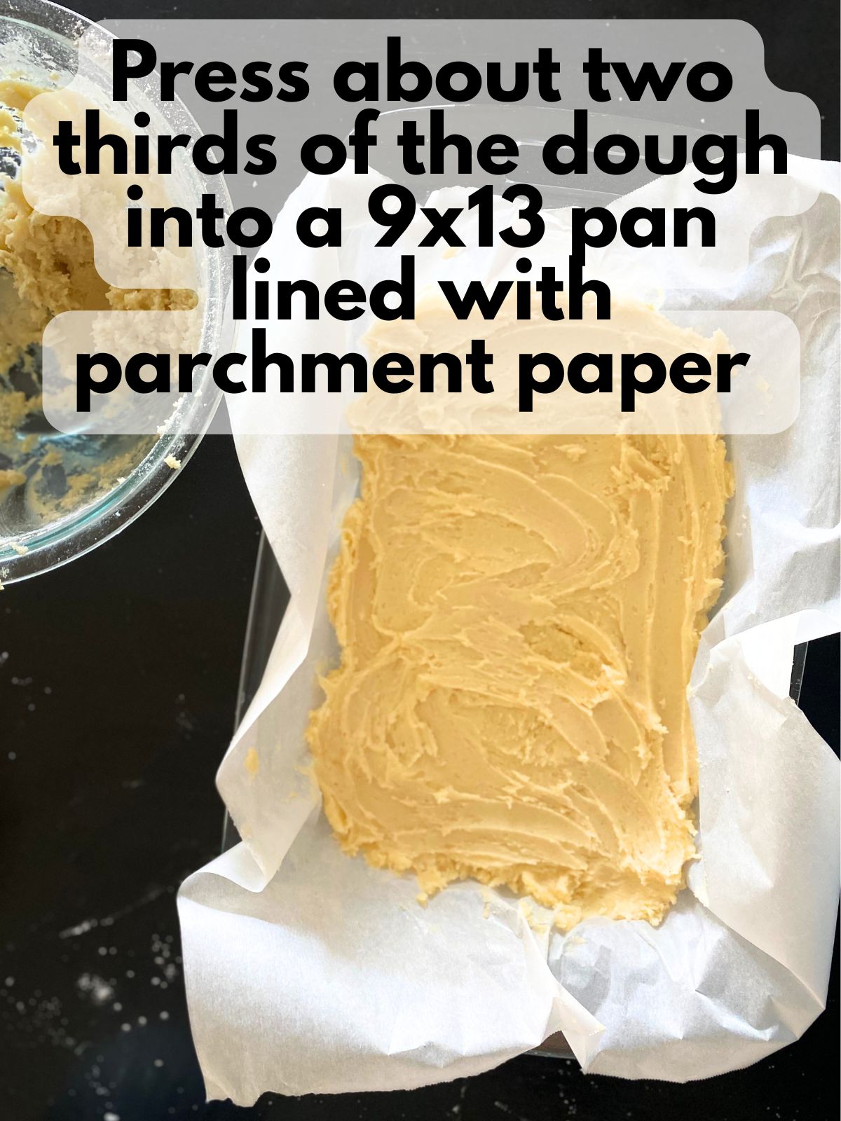 sugar cookie dough pressed into a 9x13 pan lined with parchment paper