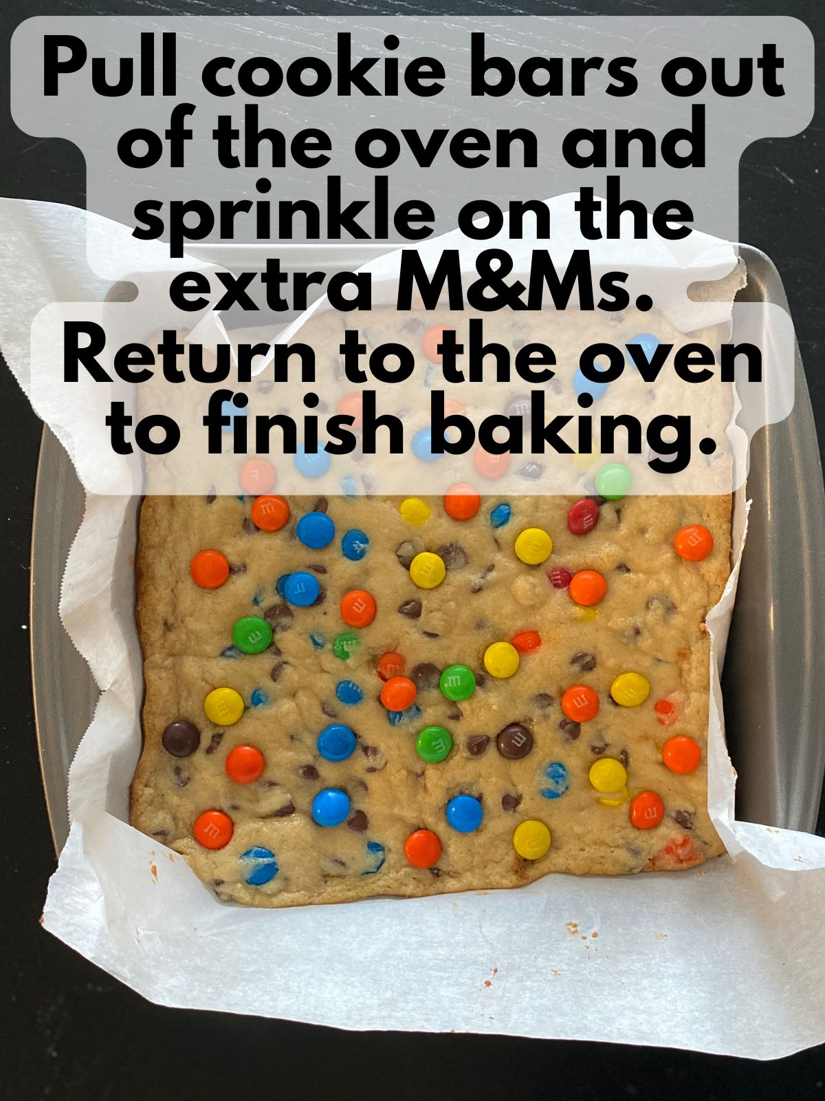 parbaked cookie bars with extra M&Ms sprinkled on top
