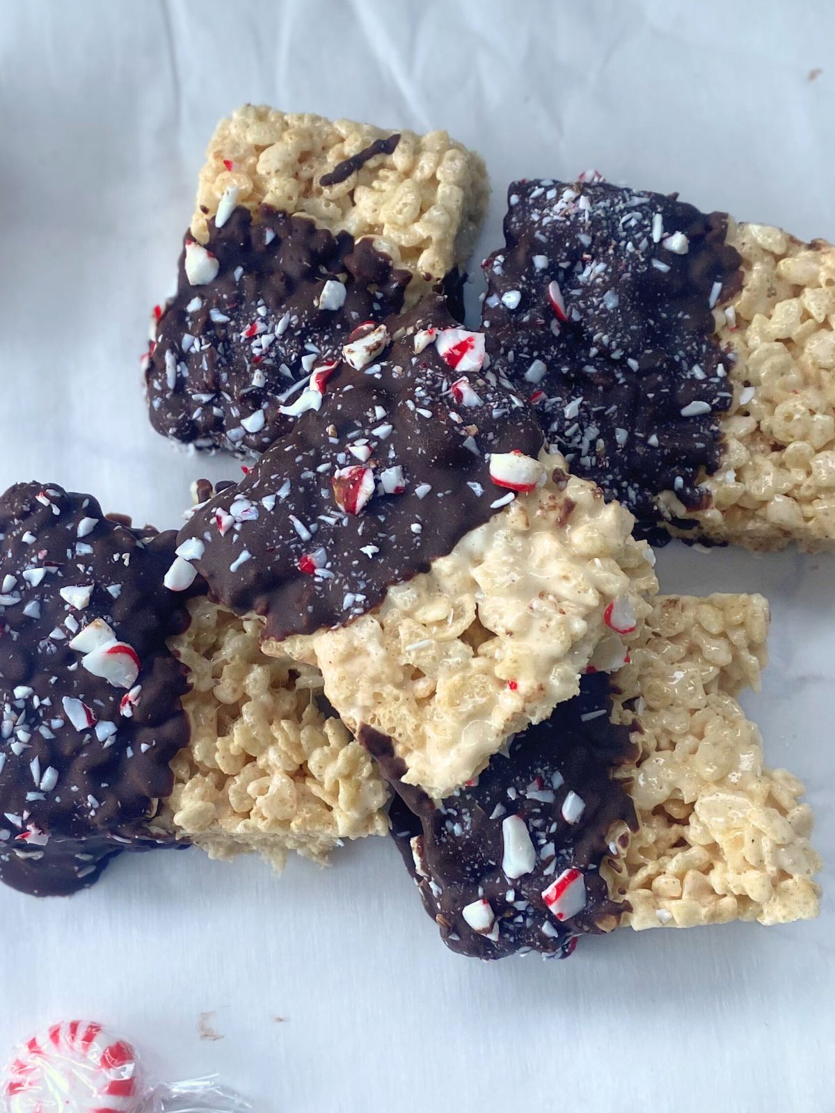 brown butter rice krispie treats dipped in chocolate and crushed candy canes