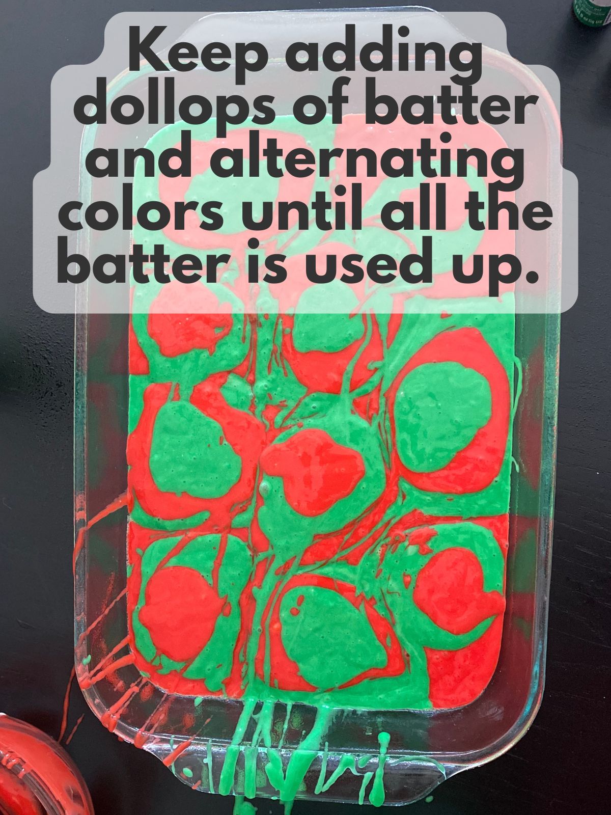 red and green batter dolloped in a greased 9x13 baking pan