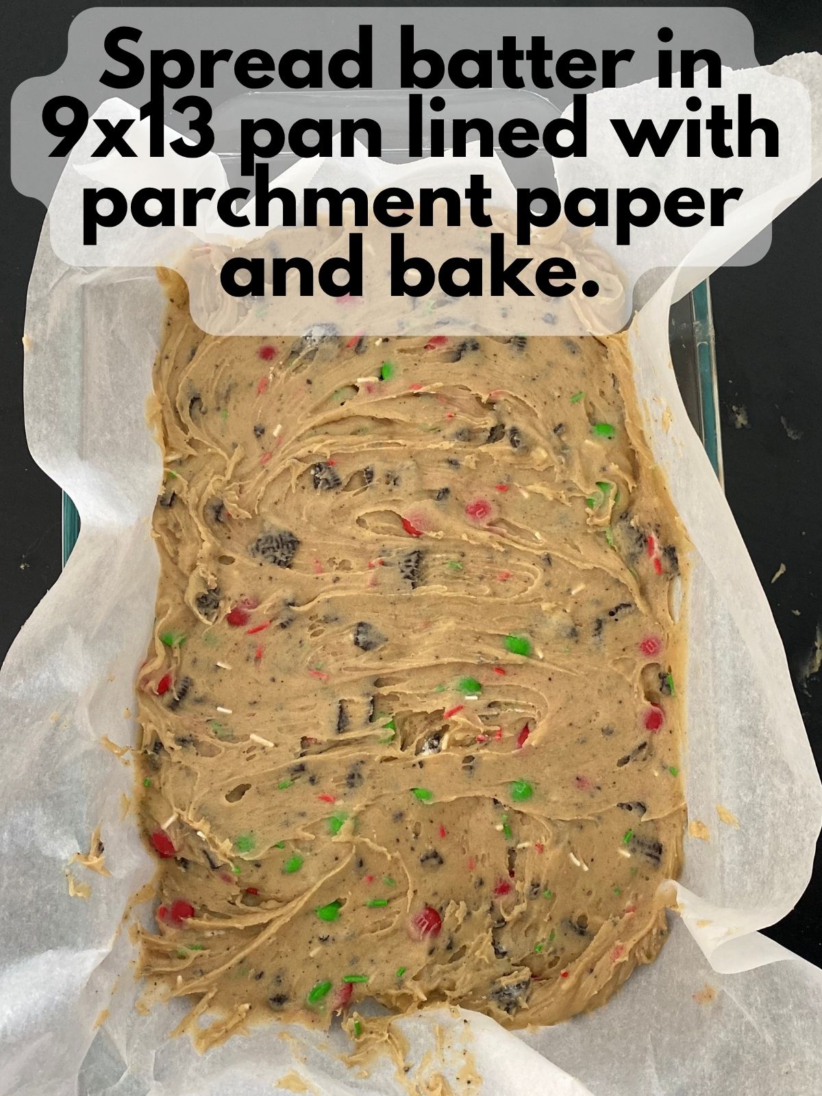 Christmas blondie batter spread in a 9x13 pan